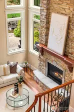Focal full-height stone fireplace with custom mantel and raised hearth