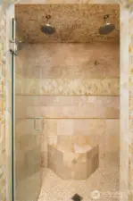 Stone encased shower with designer accents and seating