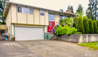 Curb appeal with mature shrubs and character.