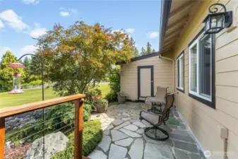 Tucked off the back deck you can find this adorable sitting area that leads down to lower level patio and garden shed