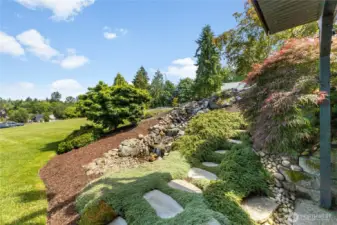 Waterfall feature has low voltage lighting and auto fills. The stepping stones connects both lower level and upper. Tastefully landscaped