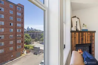 Catch a glimpse of the Seattle skyline from the living room window—just beside the warm glow of the gas fireplace.