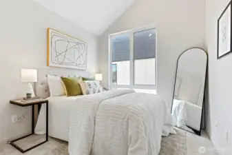 This dreamy bedroom is a sunlit retreat featuring vaulted ceilings, large windows, and just the right amount of personality.