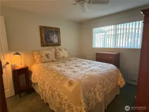 Window to the primary bedroom faces the side yard at the end of the covered deck.