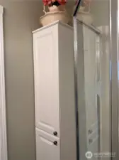 Full cabinet for storage in primary bathroom.