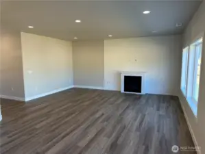 Family with gas fireplace, quartz mantel and LVP floors