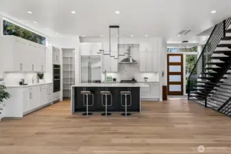 An entertainer’s kitchen with an edge.  The heart of 4015A centers around this striking chef’s kitchen, anchored by a charcoal-stained island and flanked by crisp white cabinetry and top-tier appliances. An oversized pantry and thoughtful lighting elevate both form and function, while the wide-plank oak flooring brings warmth to the modern palette.