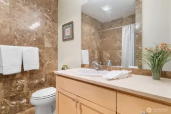 The Mainbath is conveniently located near the second bedroom and main living space, this full bathroom features rich marble tile, a sleek vanity, and a tub/shower combo