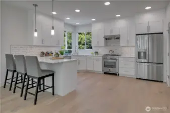 Unit B spacious main floor kitchen with eating bar & quality finishes/features throughout.