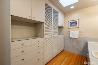 Ample en-suite bathroom storage with built-in double dressers & linen closet.