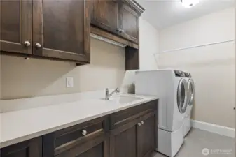 The spacious laundry room features an Electrolux washer and dryer with pedestals (installed in April 2020), offering both functionality and style.