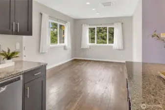 Kitchen open to the dining area that looks onto the side yard and backyard.