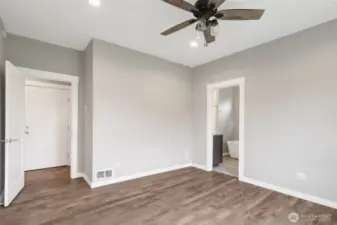 Primary bedroom with ensuite bath with soaking tub, shower, and water closet.
