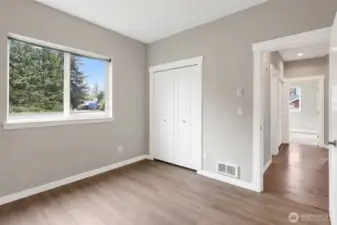 Third bedroom with new LVP flooring looking to the hall with the bathroom separates the bedrooms for privacy, and hallway entry closet.