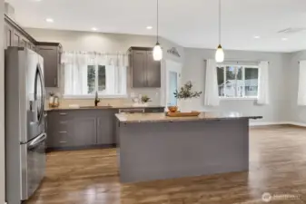Nicely appointed kitchen with island with eating bar with granite countertops, and plenty of cabinet storage. The stainless steel appliances are included. The kitchen window looks out onto the backyard and the dining room.