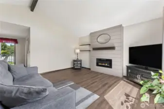 living room features new flooring and a modern electric fireplace