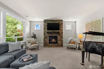 Sunlight fills this elegant room, showcasing mature hydrangeas outside while you unwind in comfort by the warmth of a gas fireplace.