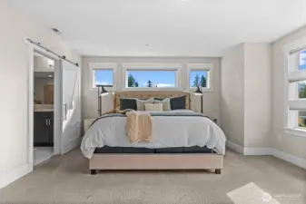 A barn door entry to the bathroom provides privacy while saving space, combining functionality with charming style.