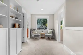 The primary bedroom and a guest suite are tucked at one end of the hall, while the loft and three additional bedrooms occupy the opposite end.