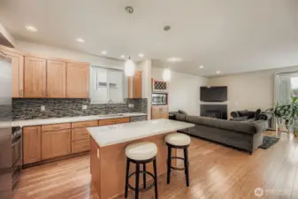 Open concept kitchen looking into living room area w/ gas fireplace