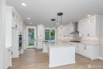 The huge gourmet kitchen features custom cabinets with upper glass detail and an abundance of counter space.