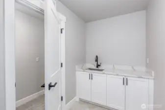 The deluxe laundry room is complete with a sink, counter and 2 walls of cabinets.
