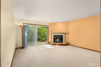 Large open living room with wood burning fireplace and private patio.