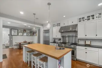 Kitchen features butcher block island with stainless steel bar sink.