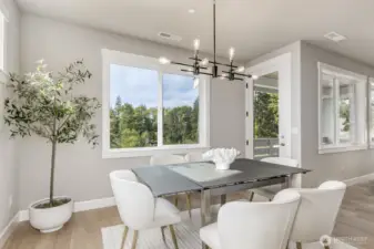 Elegant dining room with a gorgeous view of nature offers deck access.