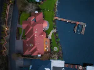 Overhead aerial highlighting the wide shoreline, private dock, and architectural roofline.