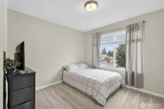 Spacious 3rd floor bedroom with neutral tones, large windows, and hardwood-style flooring