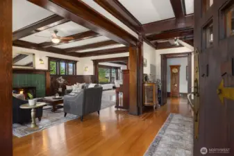 A grand introduction unfolds from the moment you step inside. Richly stained coffered ceilings, original millwork, and glowing hardwoods frame an elegant living space anchored by a classic fireplace—setting the tone for a home defined by authenticity and architectural integrity.
