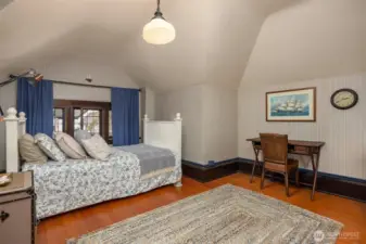 A charming upper-level bedroom features vaulted ceilings, abundant natural light, and room for both rest and study. This versatile space is perfect as a guest suite, creative studio, or private retreat tucked away from the main living areas.