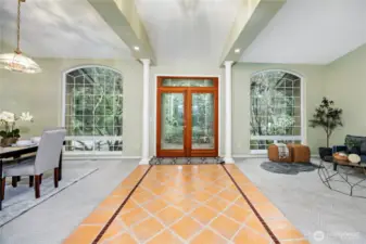Standing in the entrance looking at the front door.  Sitting area to the right dining area to the left.