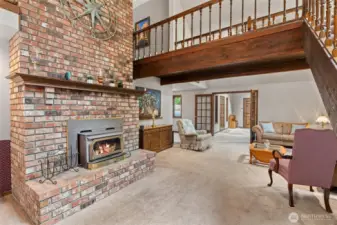 Spacious living area featuring a wood-burning masonry fireplace with two story brick chimney