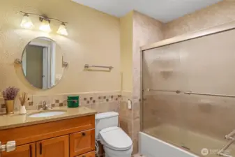 The full hall bath was thoughtfully updated and features classic tilework, a granite-topped vanity, and a full tub with shower. A perfect blend of function and warmth for household use or guests.