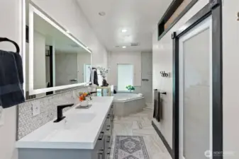 Remodeled bathroom comes with a double vanity, jetted tub, and a tiled walk-in shower.