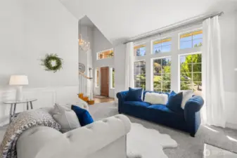 Grand Entry & Sunlit Living Room - welcome guests with this grand entryway showcasing a warm wood staircase and stunning floor-to-ceiling windows. The spacious living area offers abundant natural light and serene views of the manicured front yard.