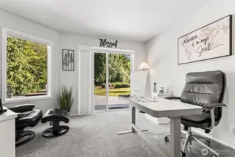 Light-Filled Home Office with Garden Views that can easily be converted into a 4th bedroom.   Spacious and serene home office featuring plush carpeting, large picture windows, and sliding glass doors that open to the backyard patio. Ideal for remote work, study, or a quiet creative retreat with inspiring views of lush greenery.