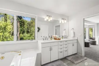 Dual Vanity Bath with Natural Light. Enjoy both style and functionality with this bright bathroom showcasing dual vanities, updated lighting, and expansive counters. Large window lets in ample sunlight while offering views of nature.