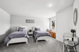 Spacious Guest Room with Twin Beds. Bright and airy guest bedroom featuring plush carpeting, neutral tones, and a cozy built-in window bench. Ideal as a shared kids’ room, guest suite, or flexible space for multi-generational living.