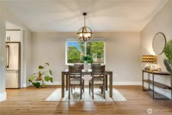 The open living and dining space features the new flooring, trim, blinds, lighting, and fresh paint found throughout the home.