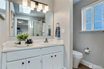 This private 3/4 bath attached to the primary suite features fresh paint, new flooring, trim, light fixtures, and shower head.
