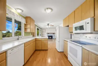 KITCHEN  White appliances – refrigerator, flat top stove, dishwasher, and microwave  Corian counters / Custom knife organizer  Peninsula with extra counter space and storage cabinets  Tall upper cabinets to maximize space  Window to front with views of Olympic Mountains, Maury Island and Puget Sound
