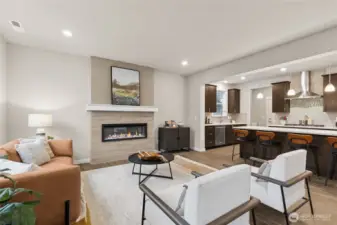Family room with cozy fireplace to gather. Gourmet kitchen with large center island, quartz counters, loads of cabinets, built-in 48" fridge and in-wall oven & microwave next to your large family room. Materials, colors, and finishes will vary. See site agent for details.