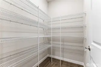 Walk-in pantry by garage entrance door.  Actual home is under construction and materials, colors, and finishes will vary. See site agent for details.