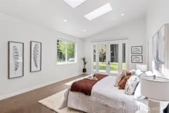 Primary bedroom with French doors to the fenced backyard.