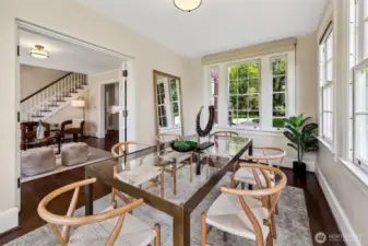 Wrapped in windows and bathed in natural light, the former sun porch now serves as an intimate dining room—an ideal perch for morning coffee or candlelit dinners. Just beyond the glass, Discovery Park breathes and rustles, lending every meal a sense of ceremony and calm.