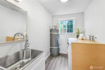 The laundry room is well-equipped with a utility sink, counter space, and natural light. Its practical layout makes household tasks more convenient.