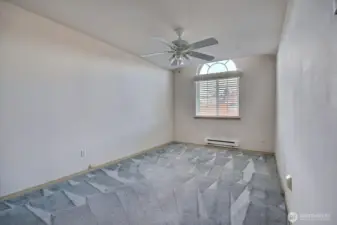 Second bedroom on the upper level features a decorative arched transom window for maximum light, newer baseboard heater and an overhead ceiling fan/light.